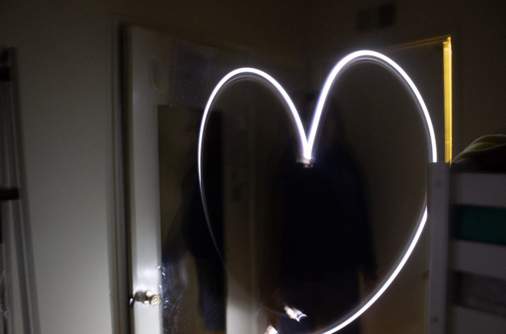 Heart made from flashlight, covering a girl's face