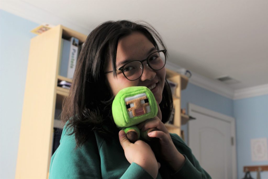 A photo of a girl holding a plush sheep from Minecraft.