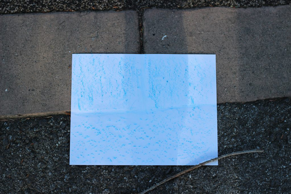 a piece of paper that has the texture of the ground sketched on to it with crayon.