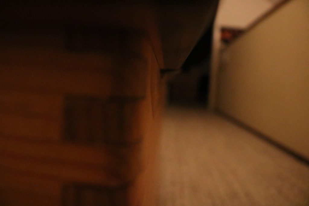 This image uses leading lines to show infinity.  The left part of the image is a closeup of a wooden box, and the right part is of a hallway with dark lines going across it.  All the lines seem to converge on a lighter part of the patch of darkness at the end of the hall.