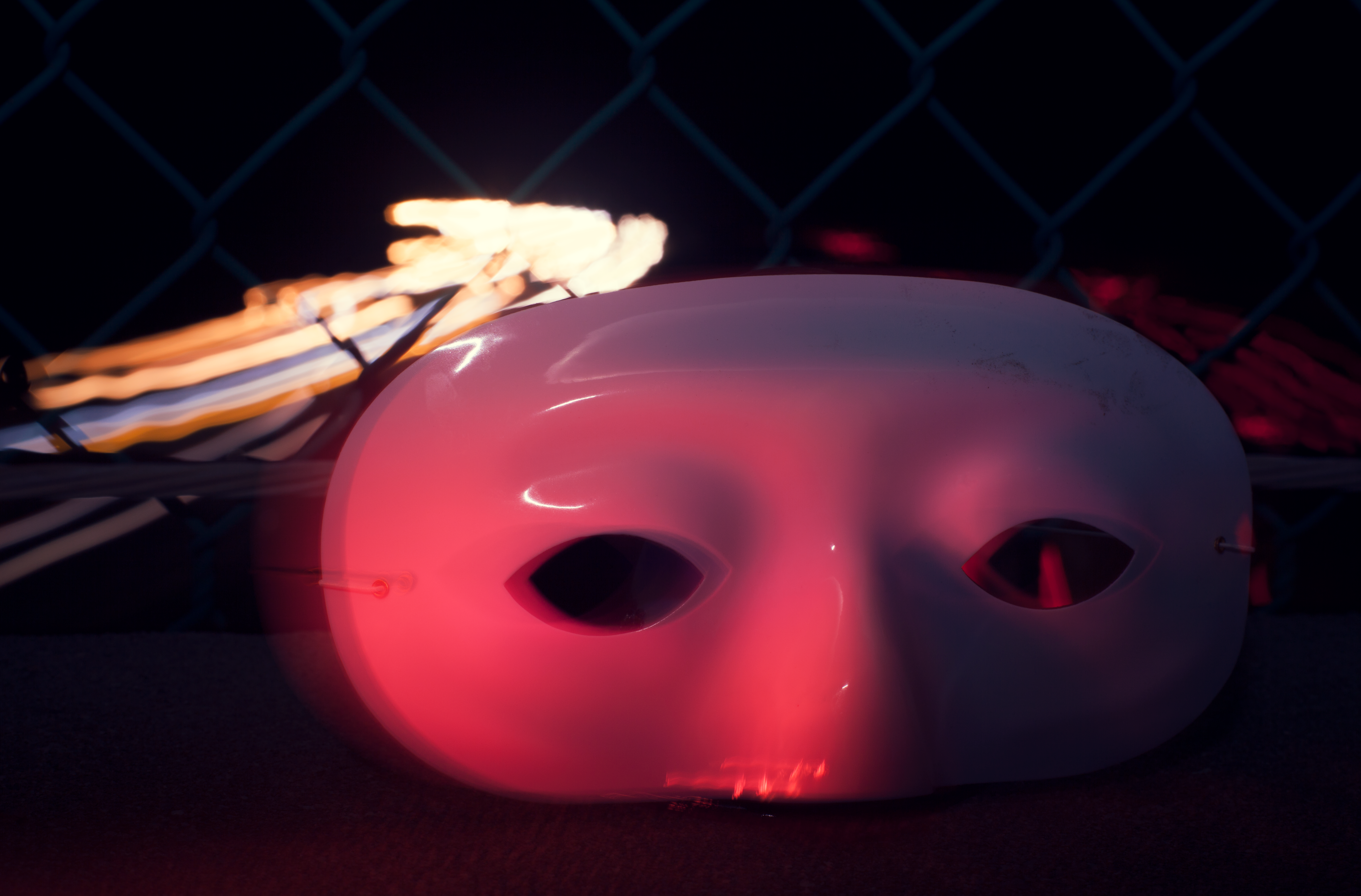 This is my conceptual photo of a mask illuminated by red light over a freeway of passing cars.