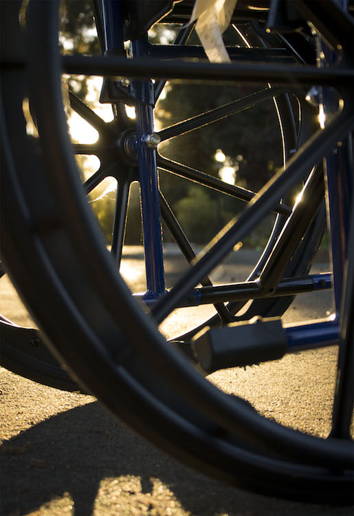 This is a photo of the wheels of a wheelchair at golden hour.