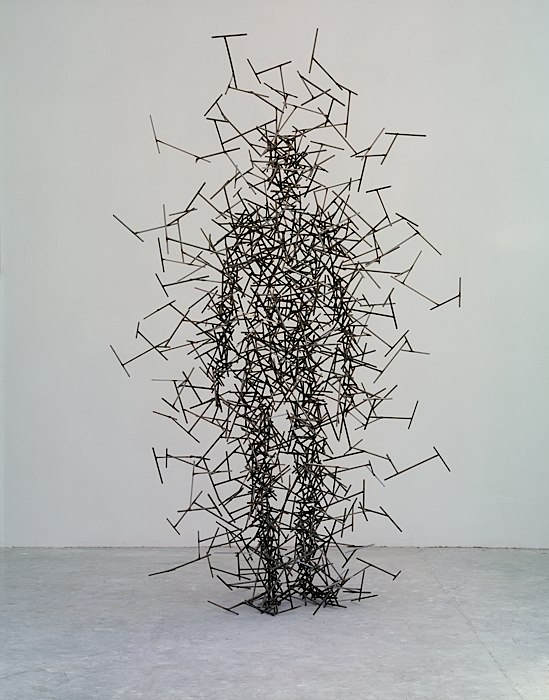 This is a photo of a metal person, which was scuplted by welding hundreds of small metal rods together to create a sillhouette of a person