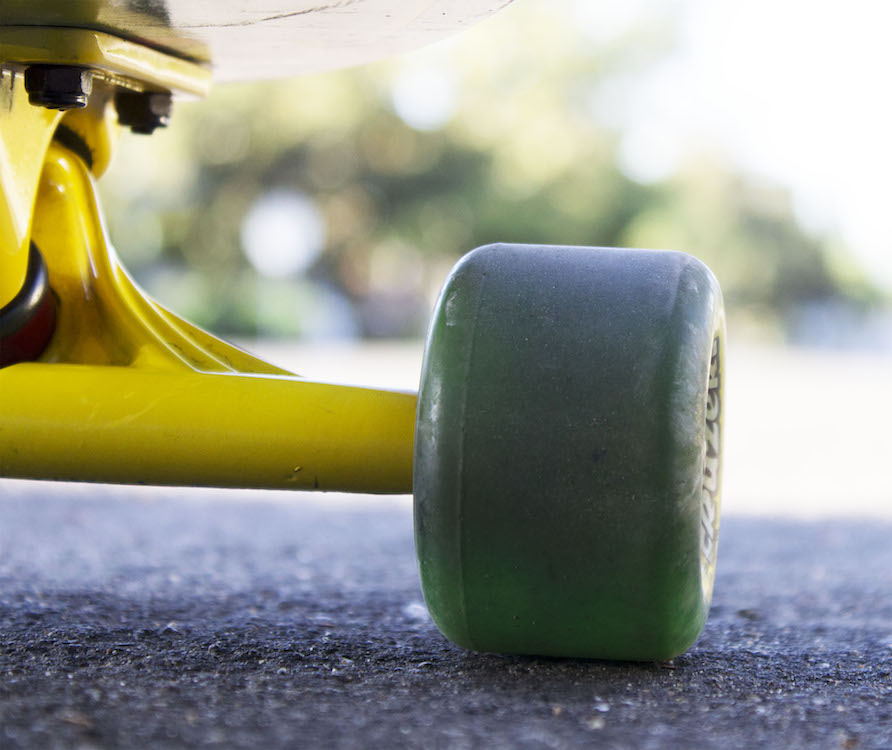 This is a photo of a green skateboard wheel at ground level