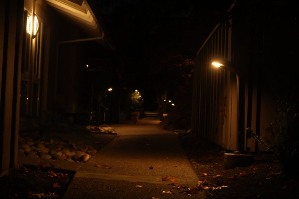 A path with orange lights that leads to darkness