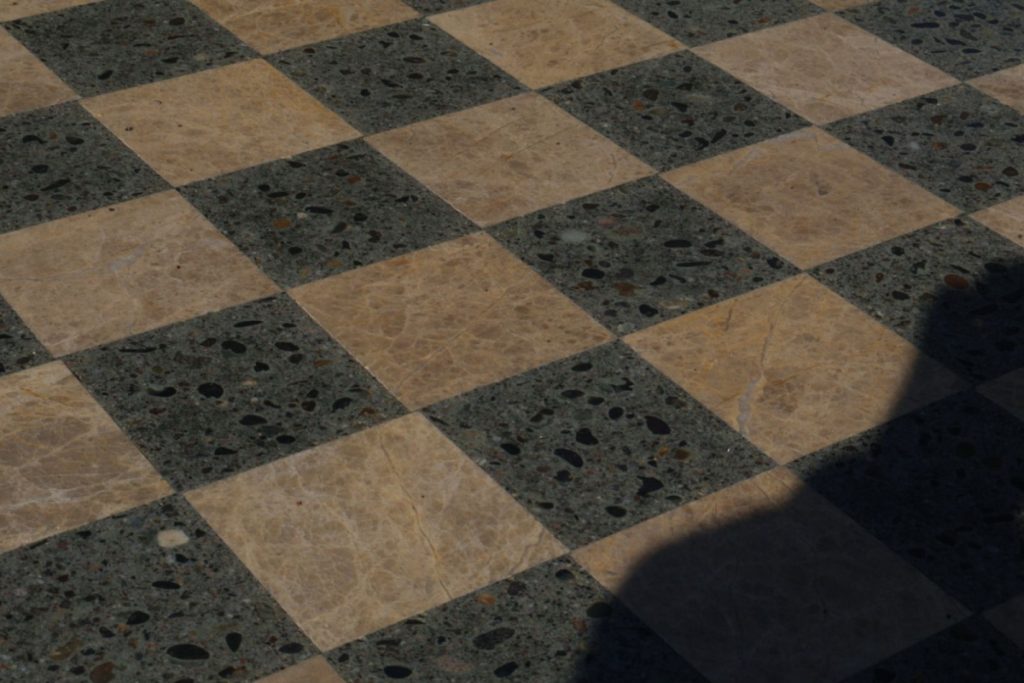 a picture of  a marble chess board from a slanted view, with a shadow on the right corner