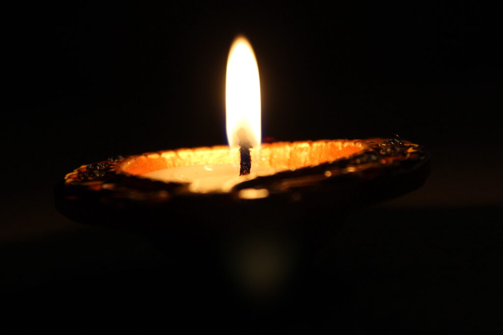 a diya surrounded by darkness