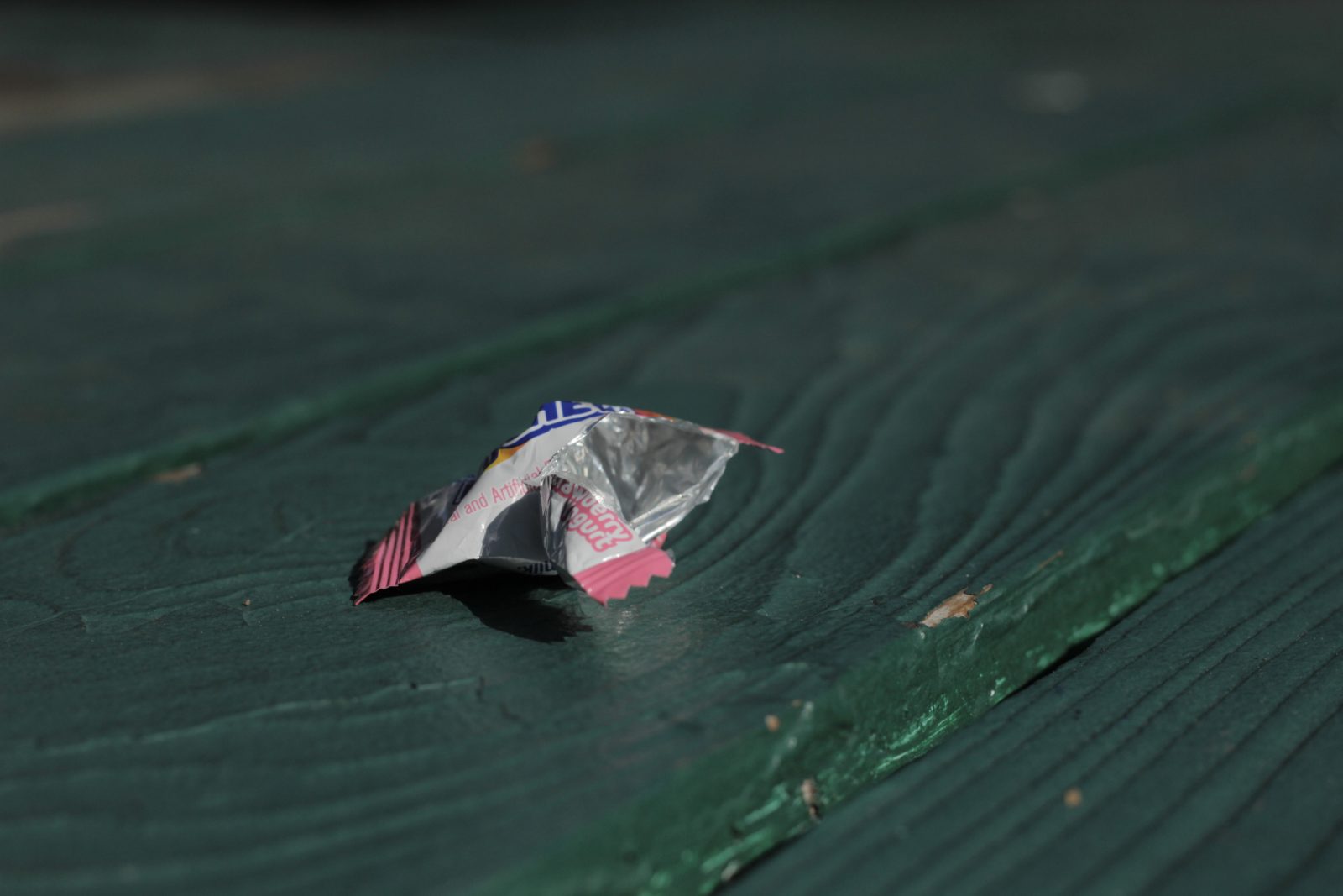 Photo of a crumpled candy wrapper in green background