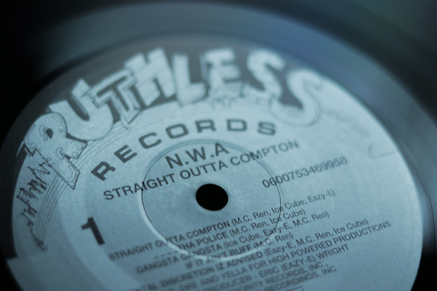 A closeup picture of a vinyl record of Straight Outta Compton by NWA. The vinyl reads, Ruthless Records, NWA Straight Outta Compton.