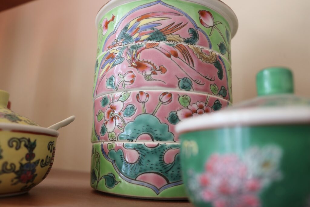 Porcelain painted in a traditional Peranakan style, featuring vivid colors of a phoenix surrounded by flowers.