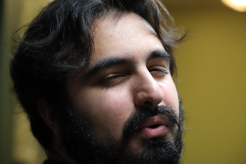 Close up a person with a beard and mustache, pursing his lips