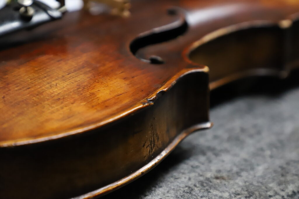 Close up with a violin with a dent on the edge