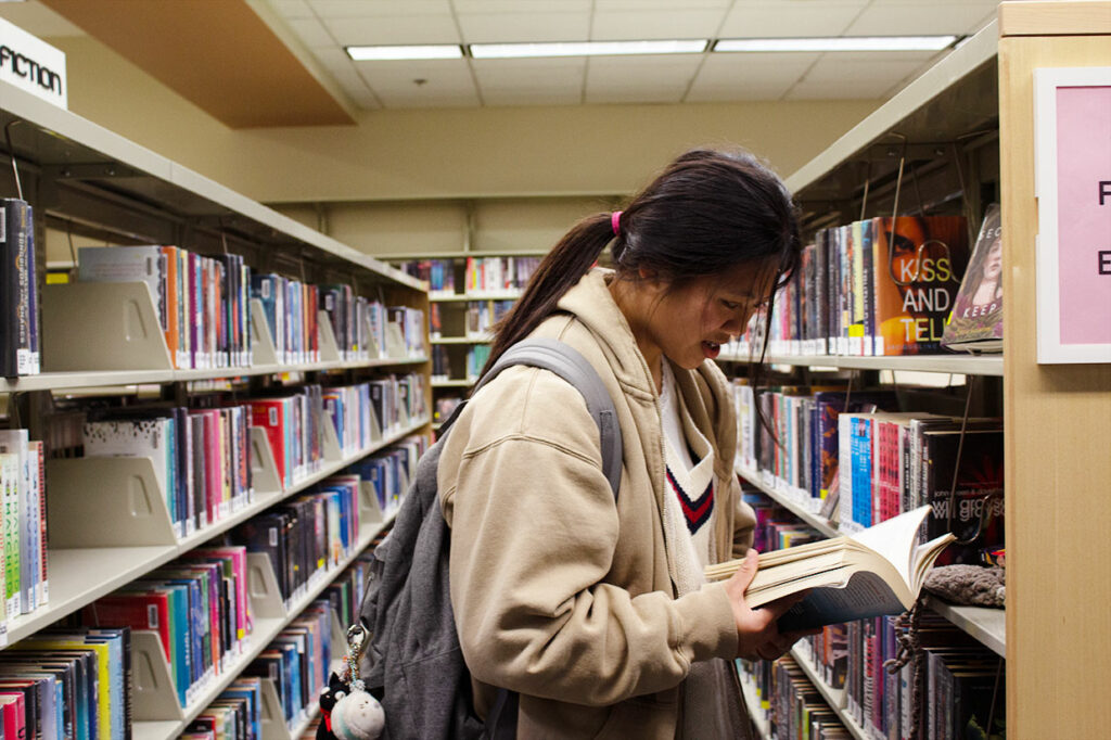 a girl reading a book at a library