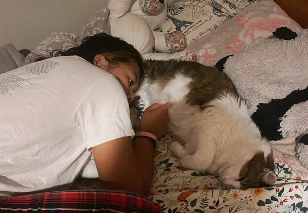 a girl and a cat lying together
