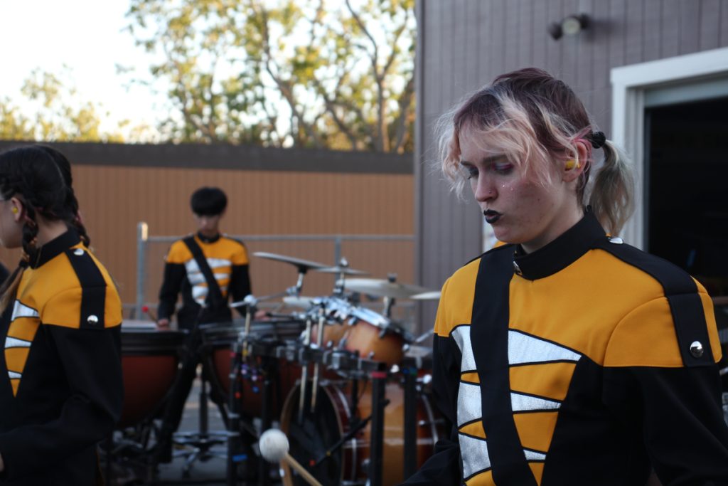 Photo of a person looking down while playing the xylophone. 