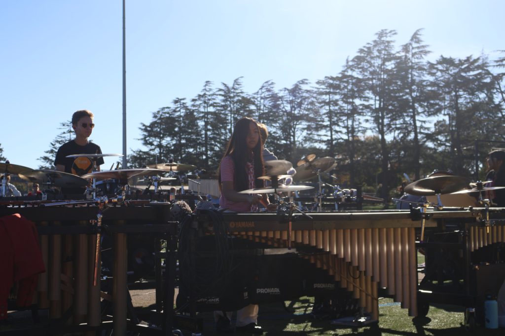 A photo of the MVHS Marching Band front ensemble, focusing on the center marimba player during the middle of a run through of the marching band's show.