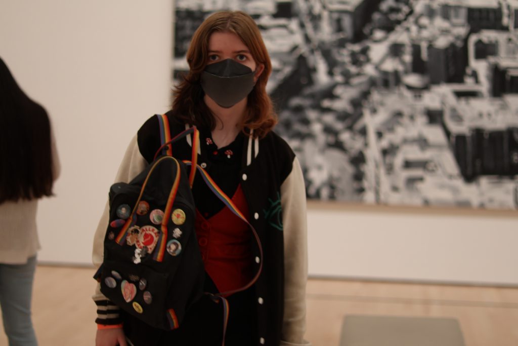 A photo of a person taken in an art museum with the background unfocused.
