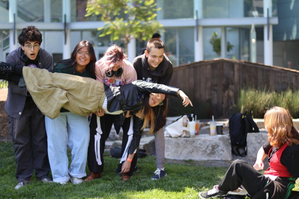 Michelangelo's "Creation of Adam" painting recreated by a group of teenagers in a park.
