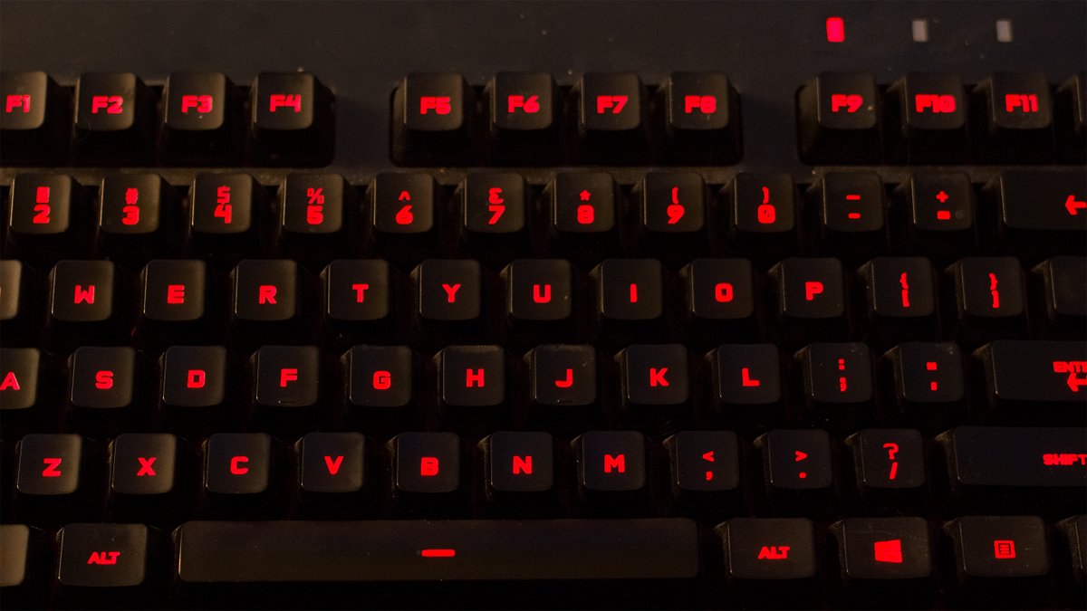 This photo is of a keyboard that is lit up with the color red. The photo shows black keycaps colored red.
