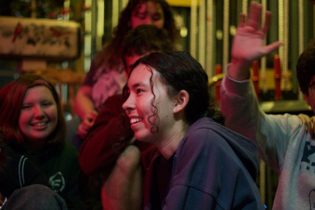 People laughing backstage in a theatre near the flyrails