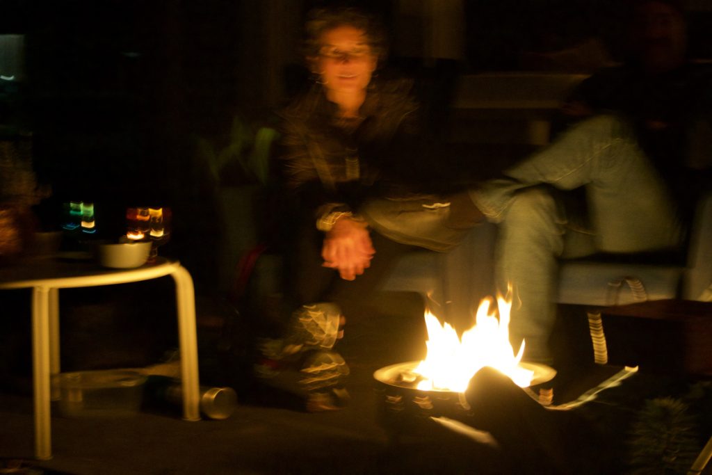 a blurry photo of people sitting around a campfire.