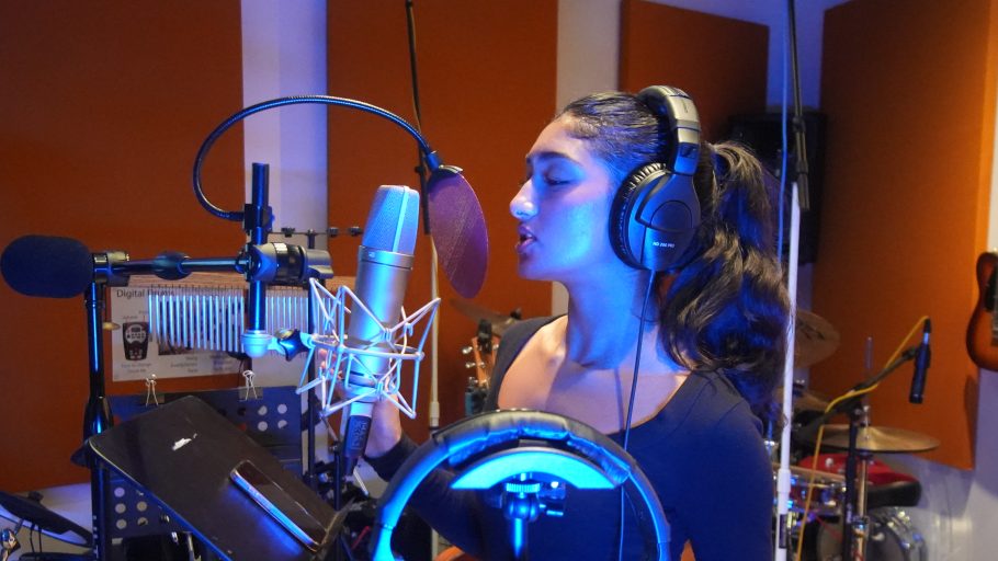 Saumya Anand at the microphone in the recording studio
