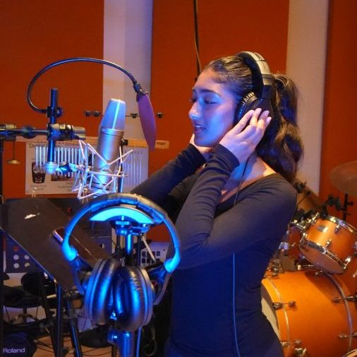 Saumya Anand singing into the microphone