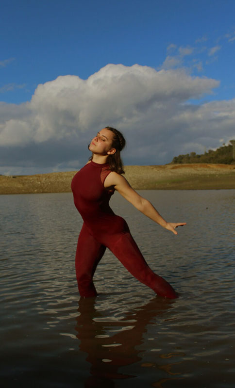 Girl in a red bodysuit dancing in the water