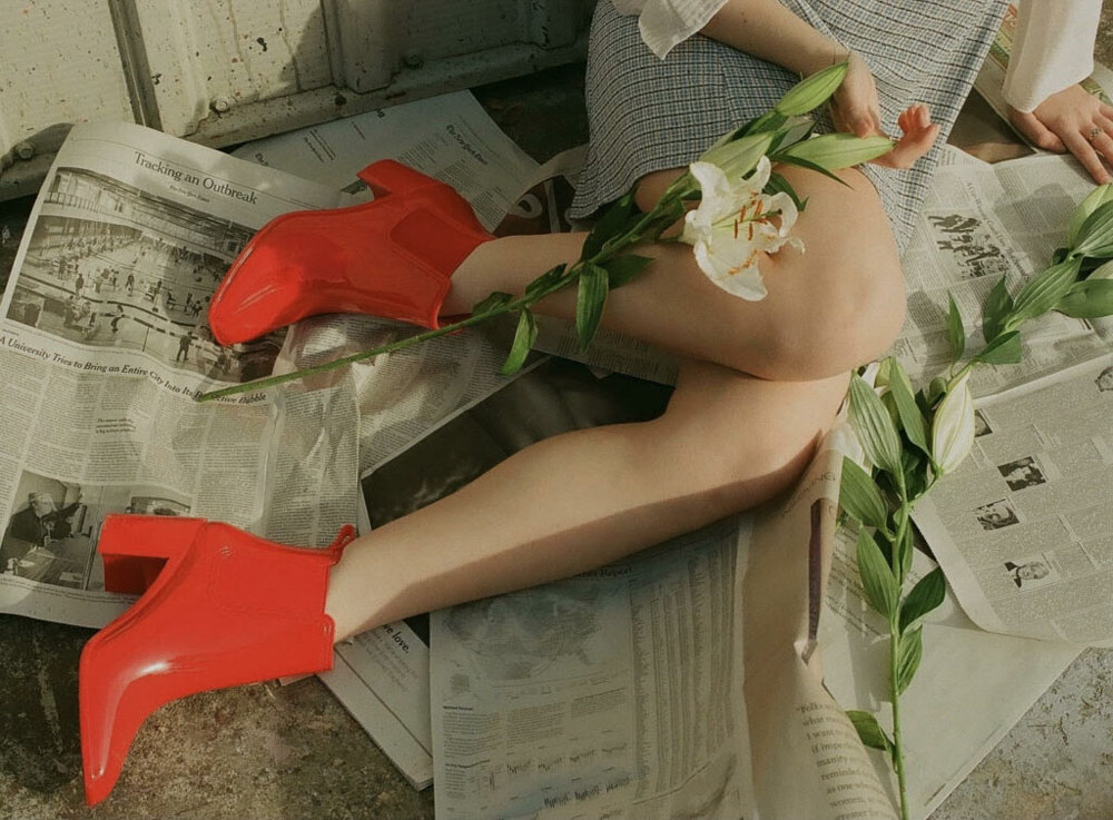 Red boots, news papers, white lilies