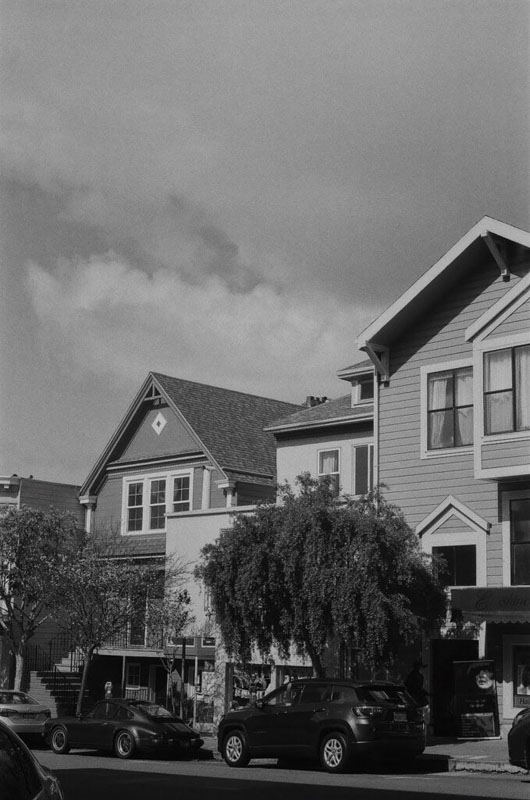 Houses with clouds and cars above and below it in San Francisco