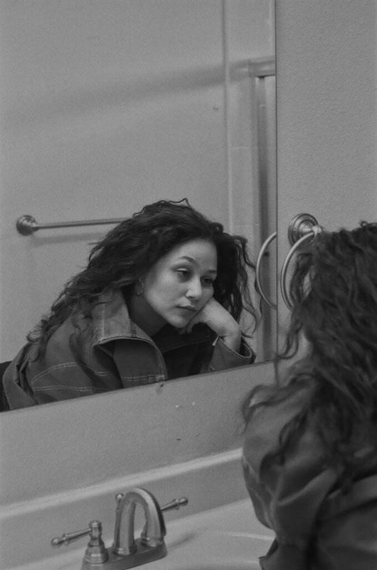 Girl looking at herself in the bathroom mirror