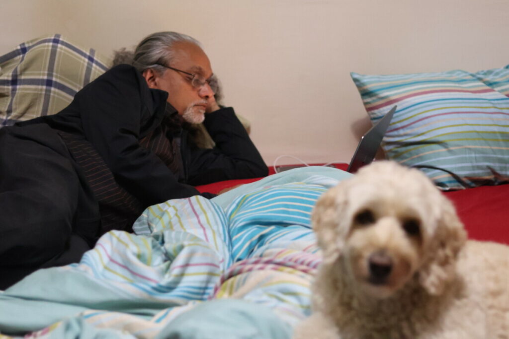 photo with dog and dad on laptop on bed