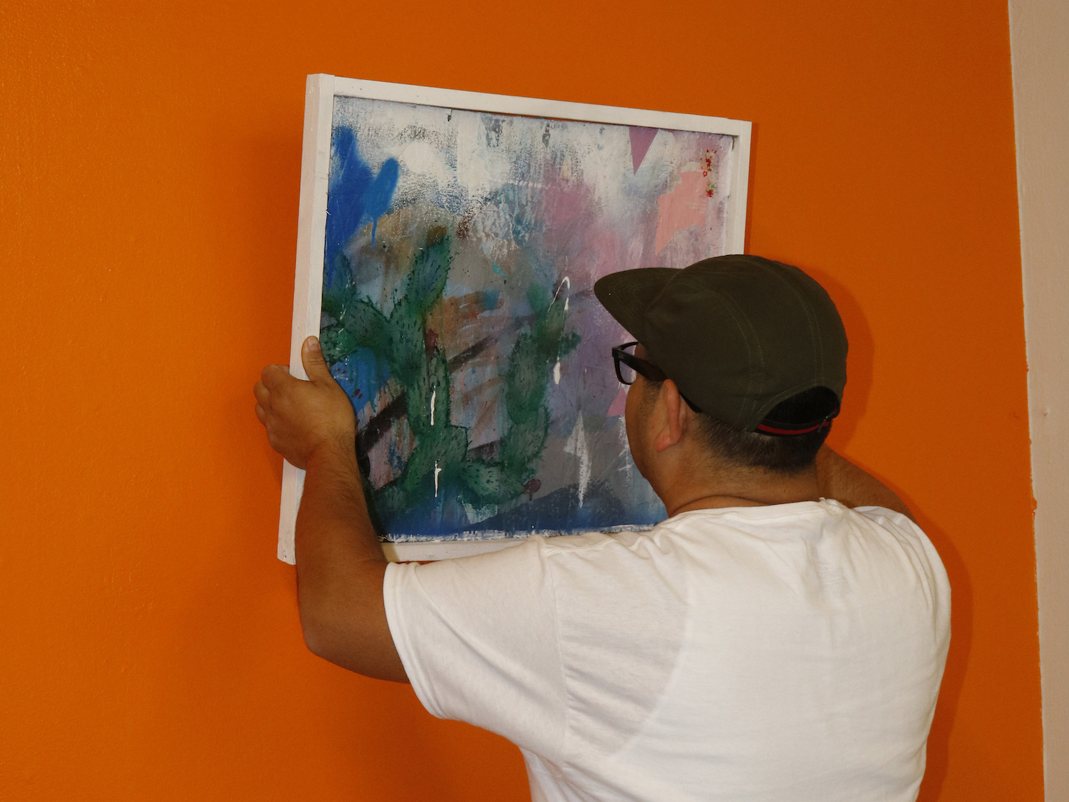 Fernando replacing a painting on the wall.
