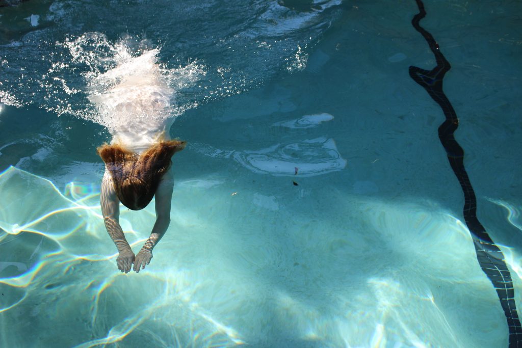 Photo following the rule of thirds that shows motion. This is a photo of a girl  swimming in a pool.