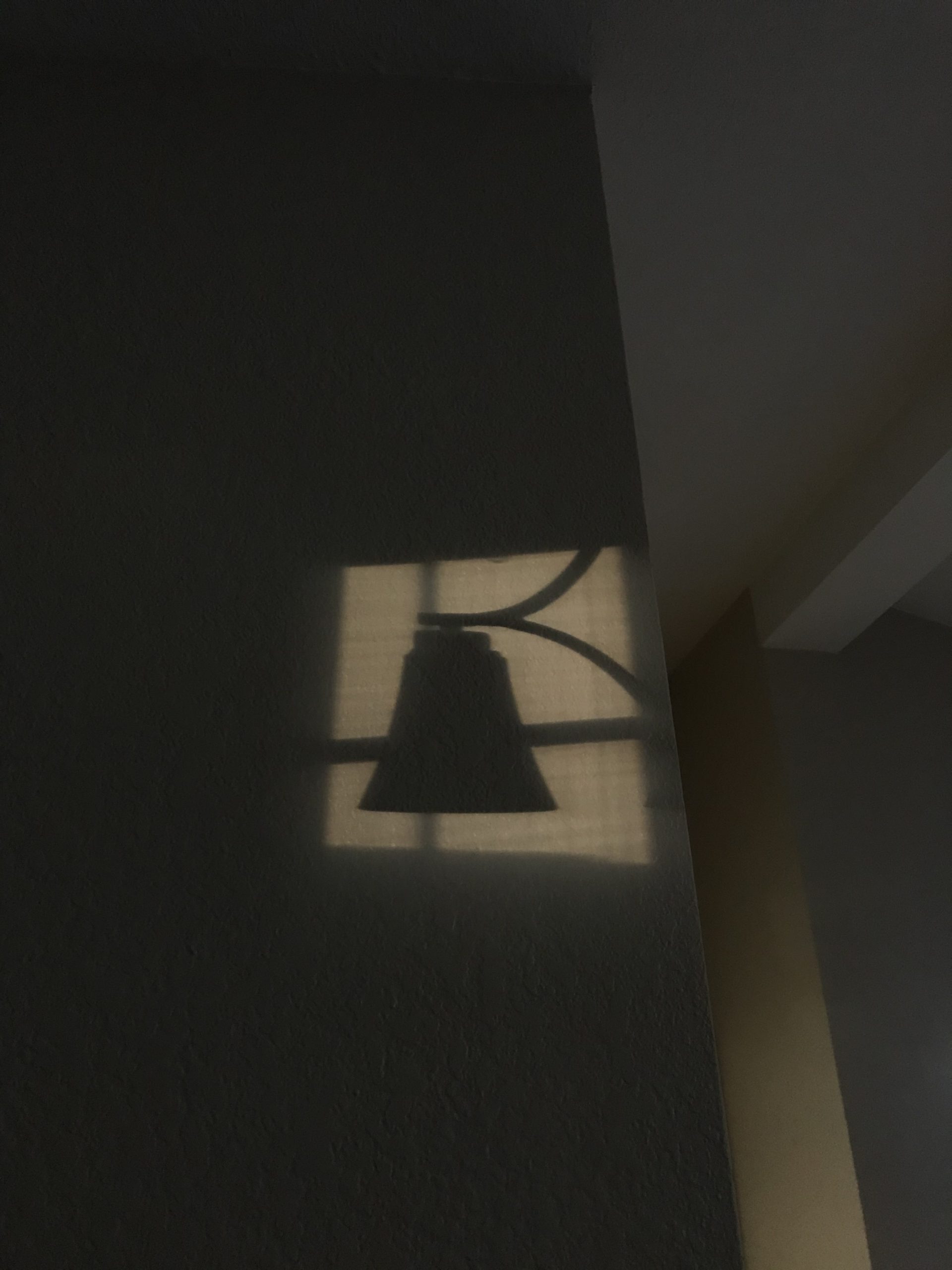 A shadow of a lamp on the wall.