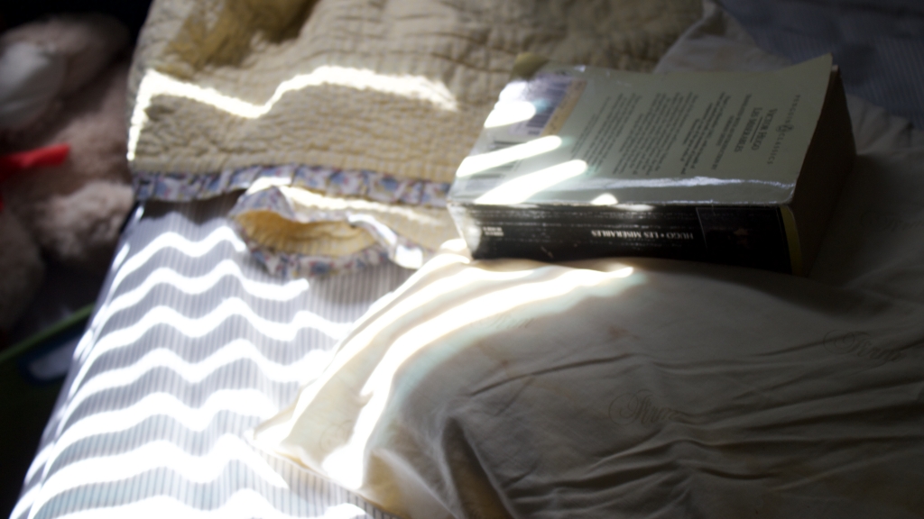 a bed with a pillow and a book on it. 