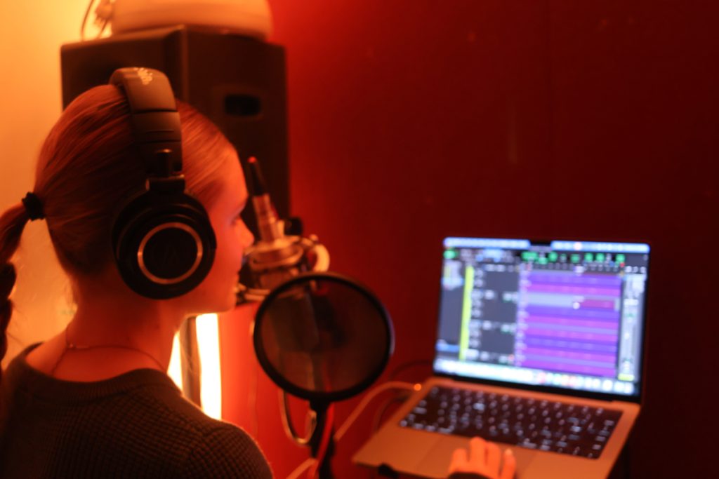 Girl in recording room looking at computer