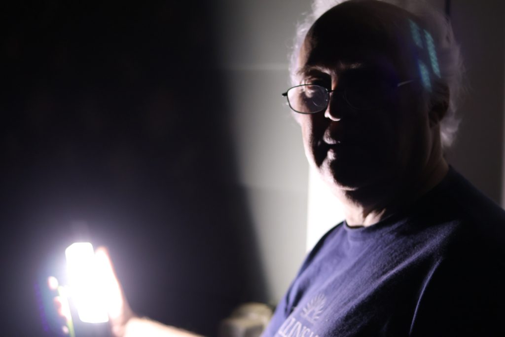 A person illuminated by a bright light that they are holding
