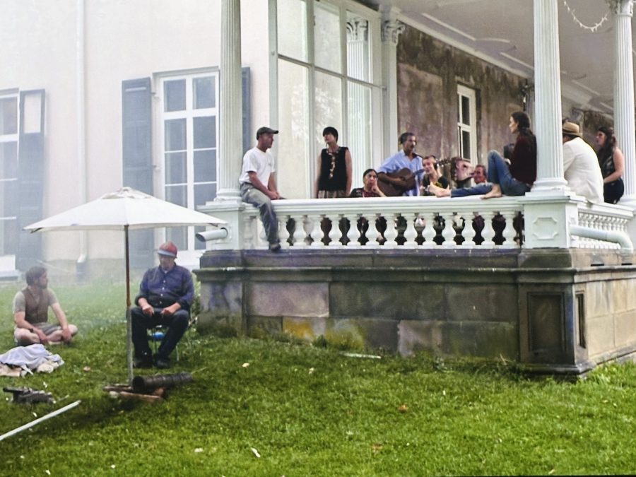 A scene in "The Visitors" where a large group of people are socializing outside