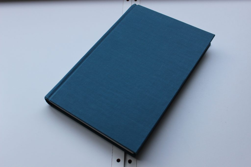 a blue, hardcover book. there are no words on the cover.