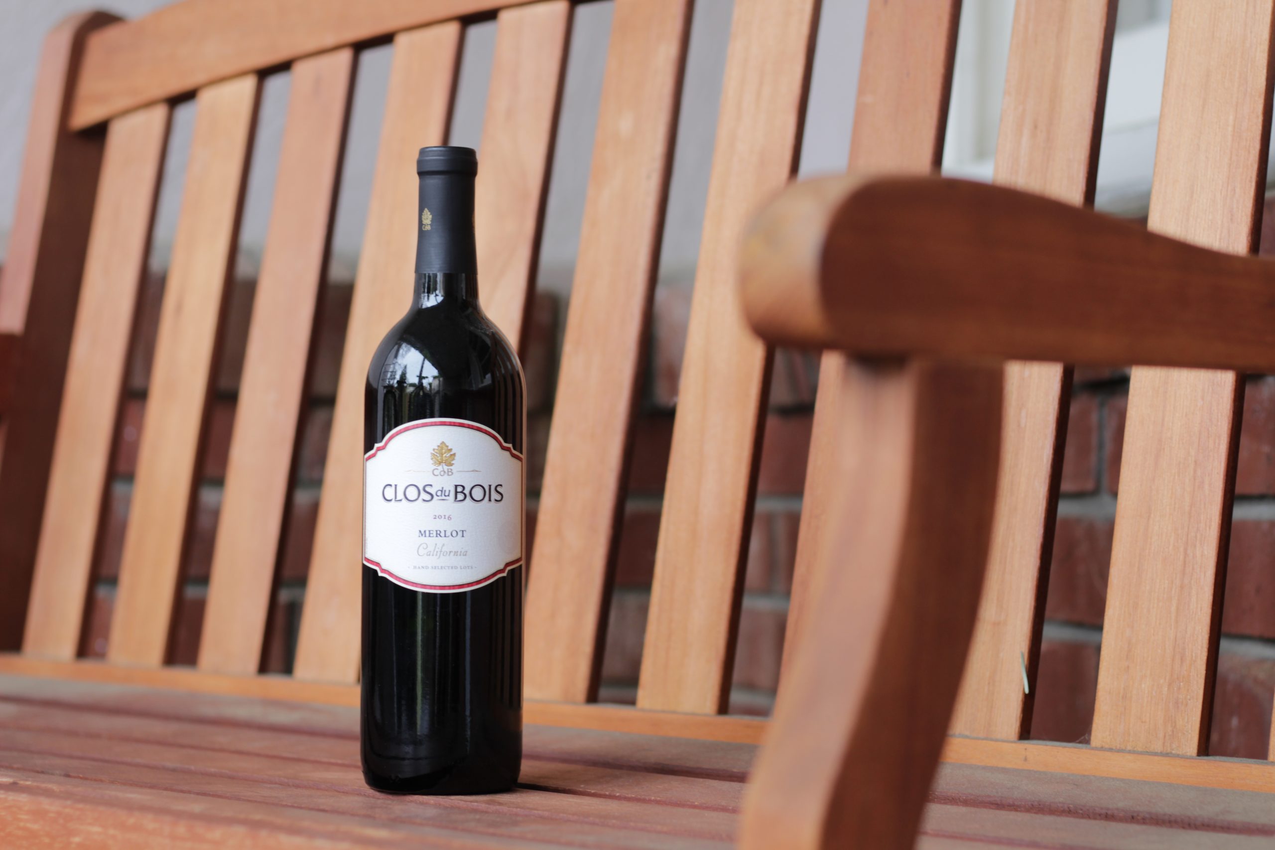 Wine bottle on a bench.