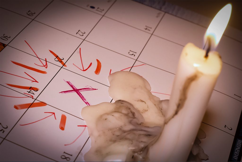 Candle melting on a calendar with a date marked off with an x and arrows