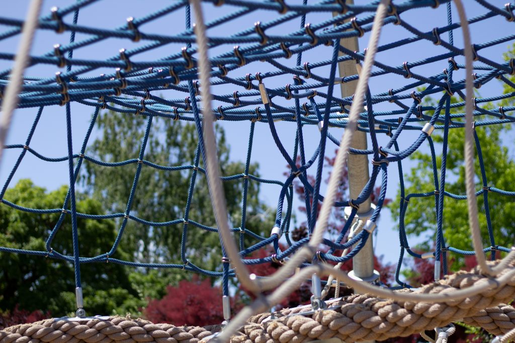 A shot of a net structure meant for climbing around on, with the whole view tied up with ropes.