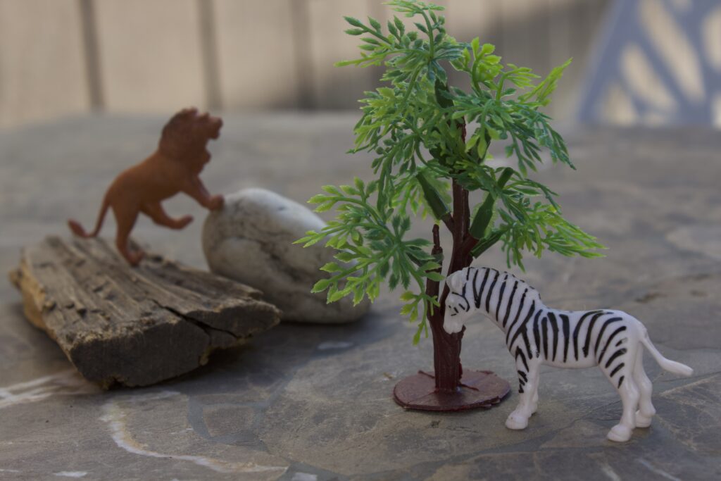 animal and tree figurines, with rocks and sticks to depict a nature scneve 
