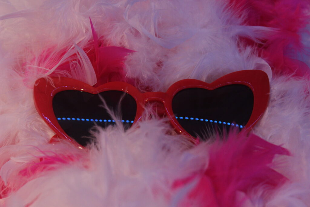 Red, heart shaped sunglasses carefully placed on top of hot pink 