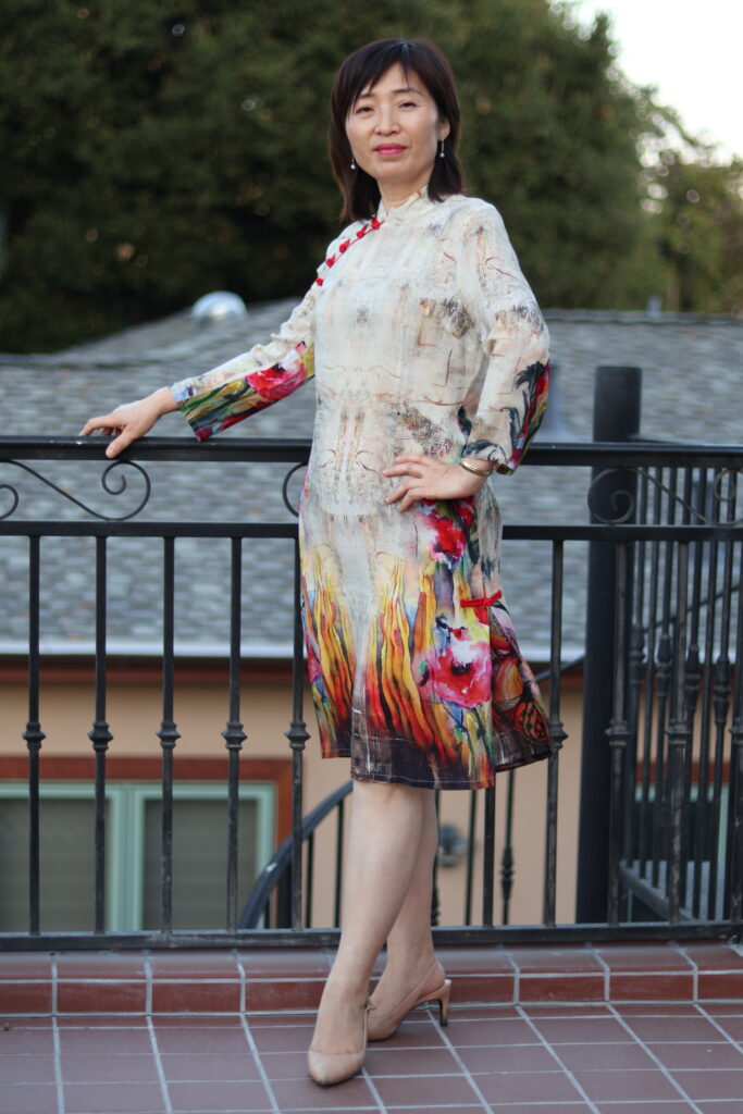 Woman standing atop a balcony, wearing a traditional Chinese garment