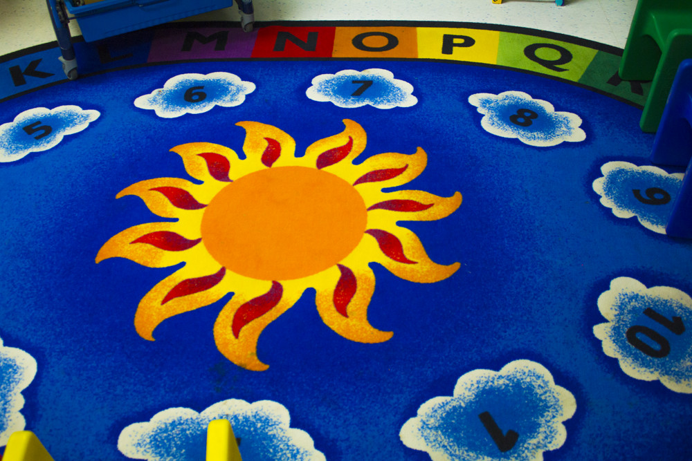 A colorful carpet with a sun in the center