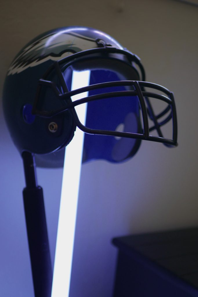 A lightsaber and an extendable boom pole holding up a Philadelphia Eagles football helmet. 