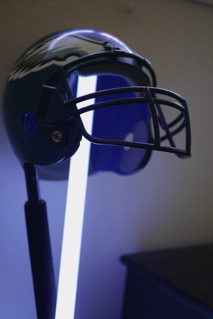 A lightsaber and an extendable boom pole holding up a Philadelphia Eagles football helmet.