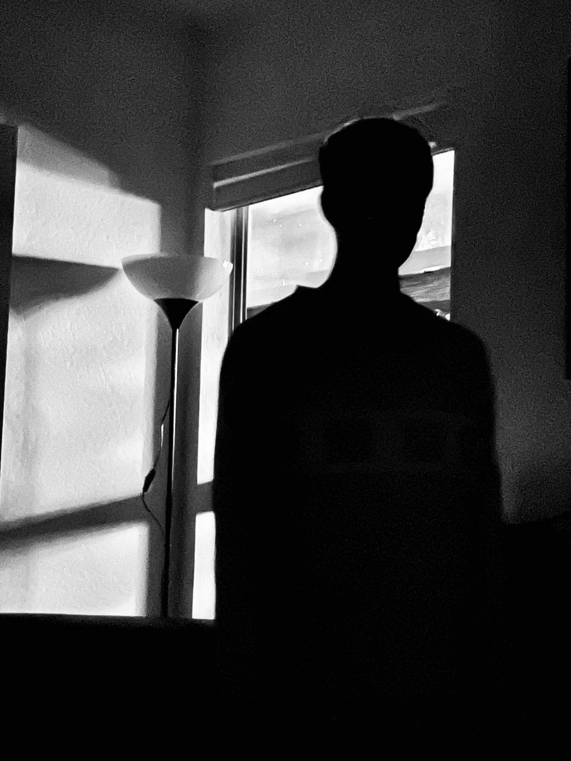 A man silhouetted against a window. 